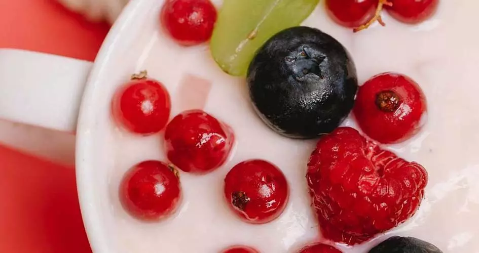 yaourt, garni de raisins, myrtilles frais, disposés sur la surface du bol